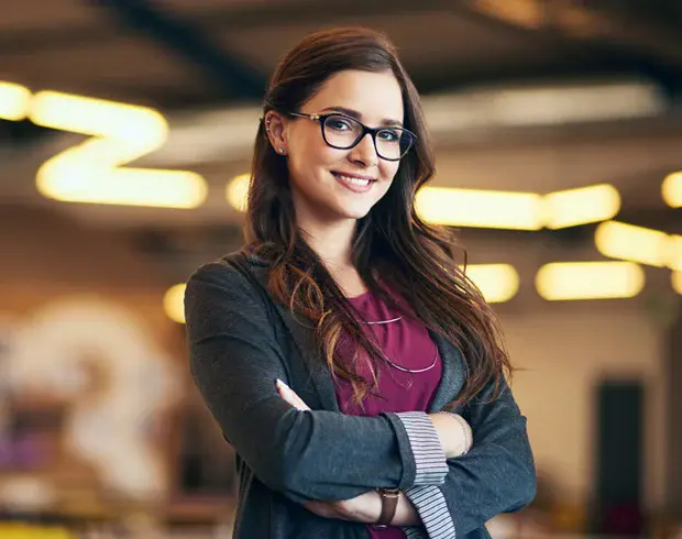 A professionally-dressed woman, smiling.